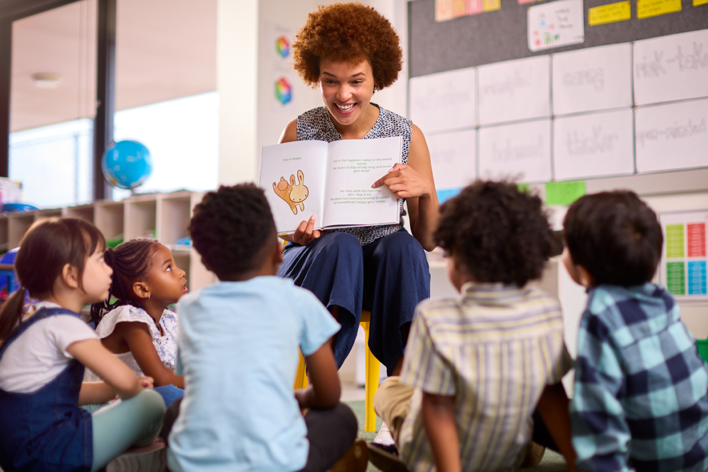 Professora lê livro para alunos.