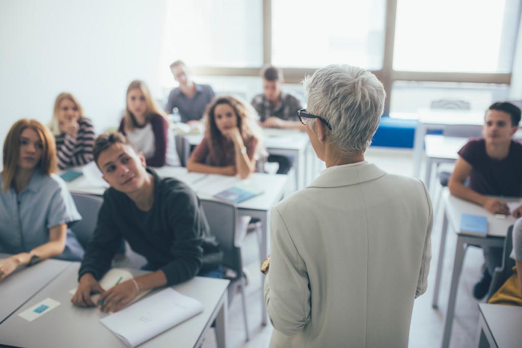 Professora ensinando em sala de aula. competências e habilidades do professor​.