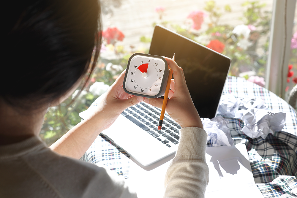 Mulher utilizando um relógio para usar o método pomodoro. 